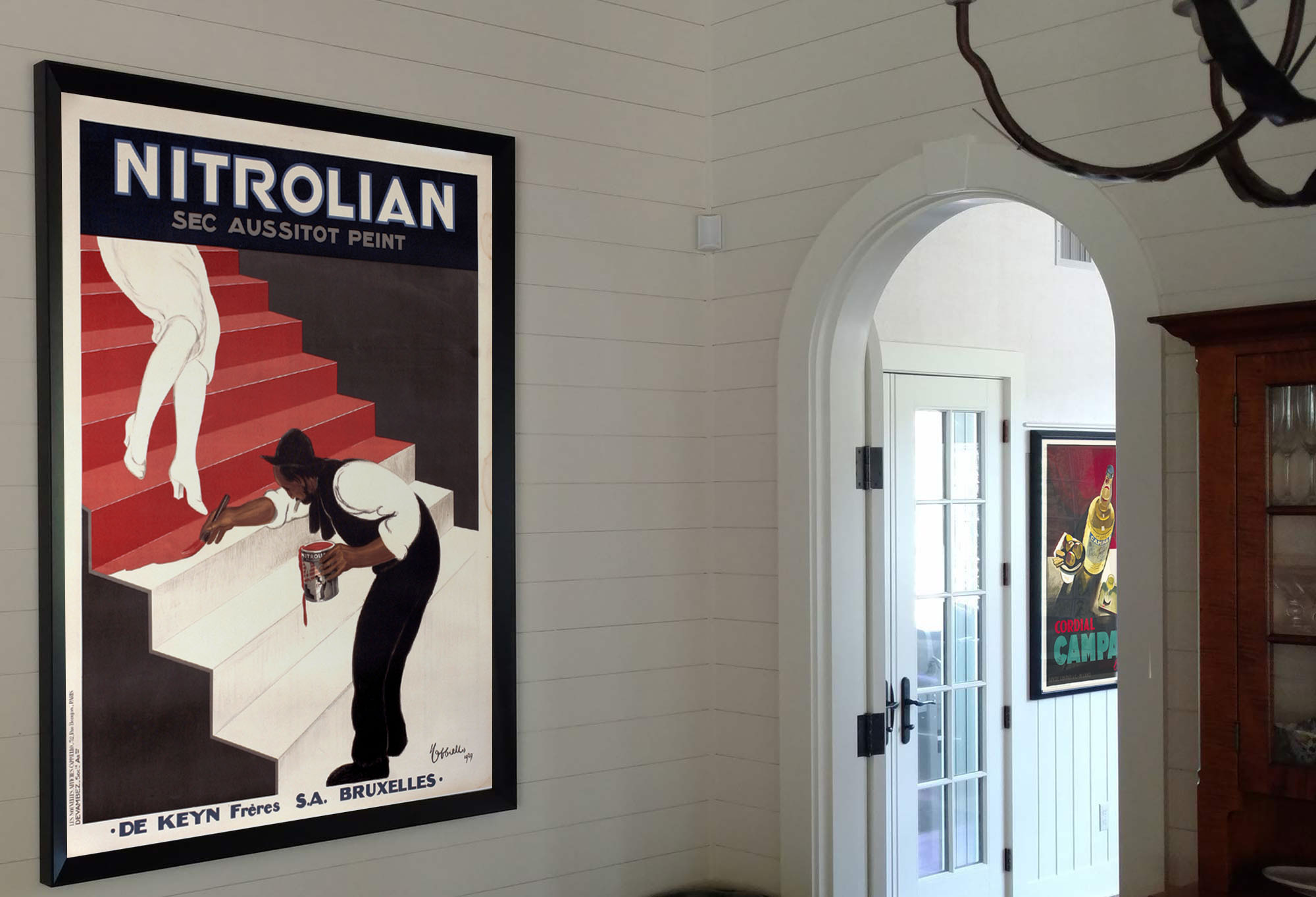 framed poster of woman in white descending stairs while man paints them red in room with open door; white, red, black